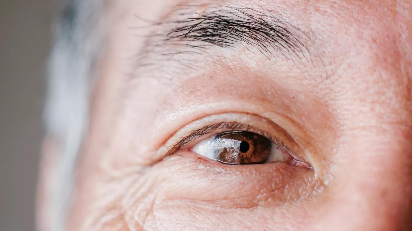 A close up of a s smiling older man's brow eye