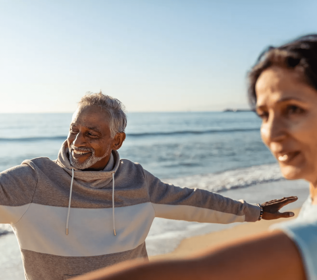 Couple faisant du yoga sur une plage