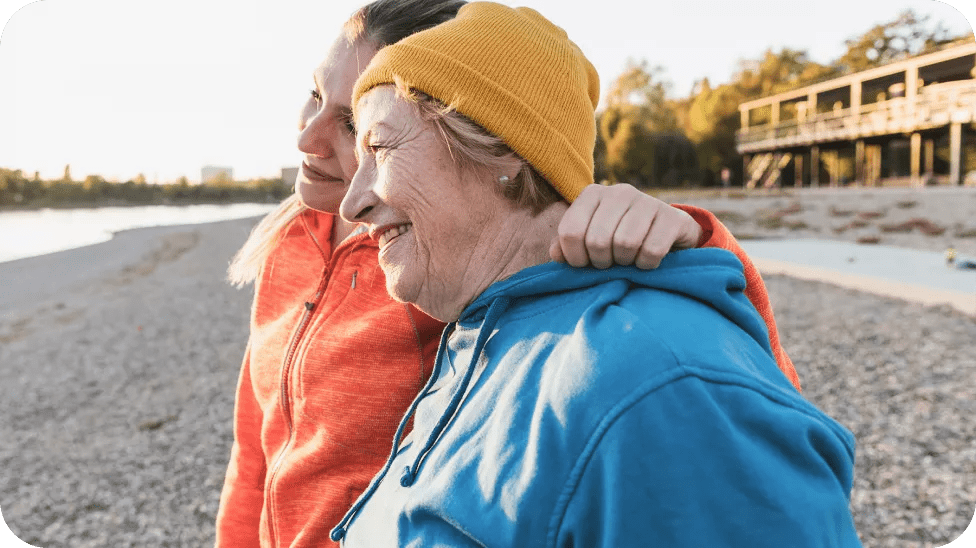 Two older people on the beach looking at the sea