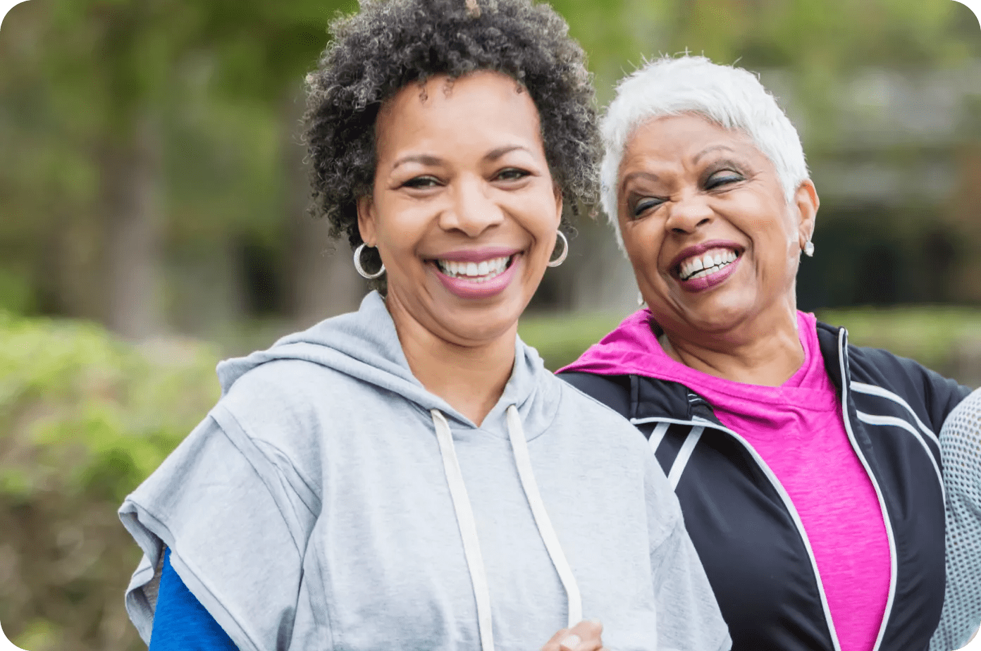 Três mulheres rindo em um parque