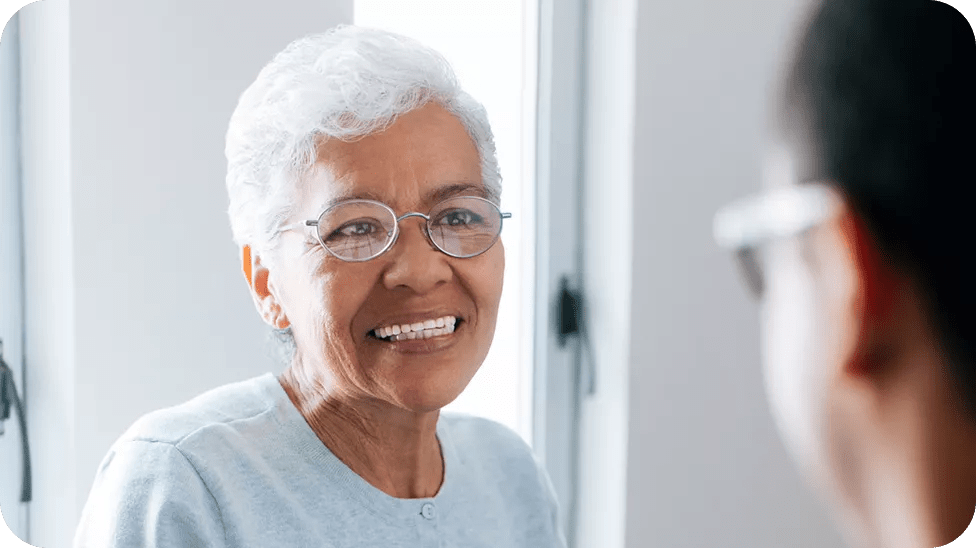 Grey haired lady wearing glasses and smiling