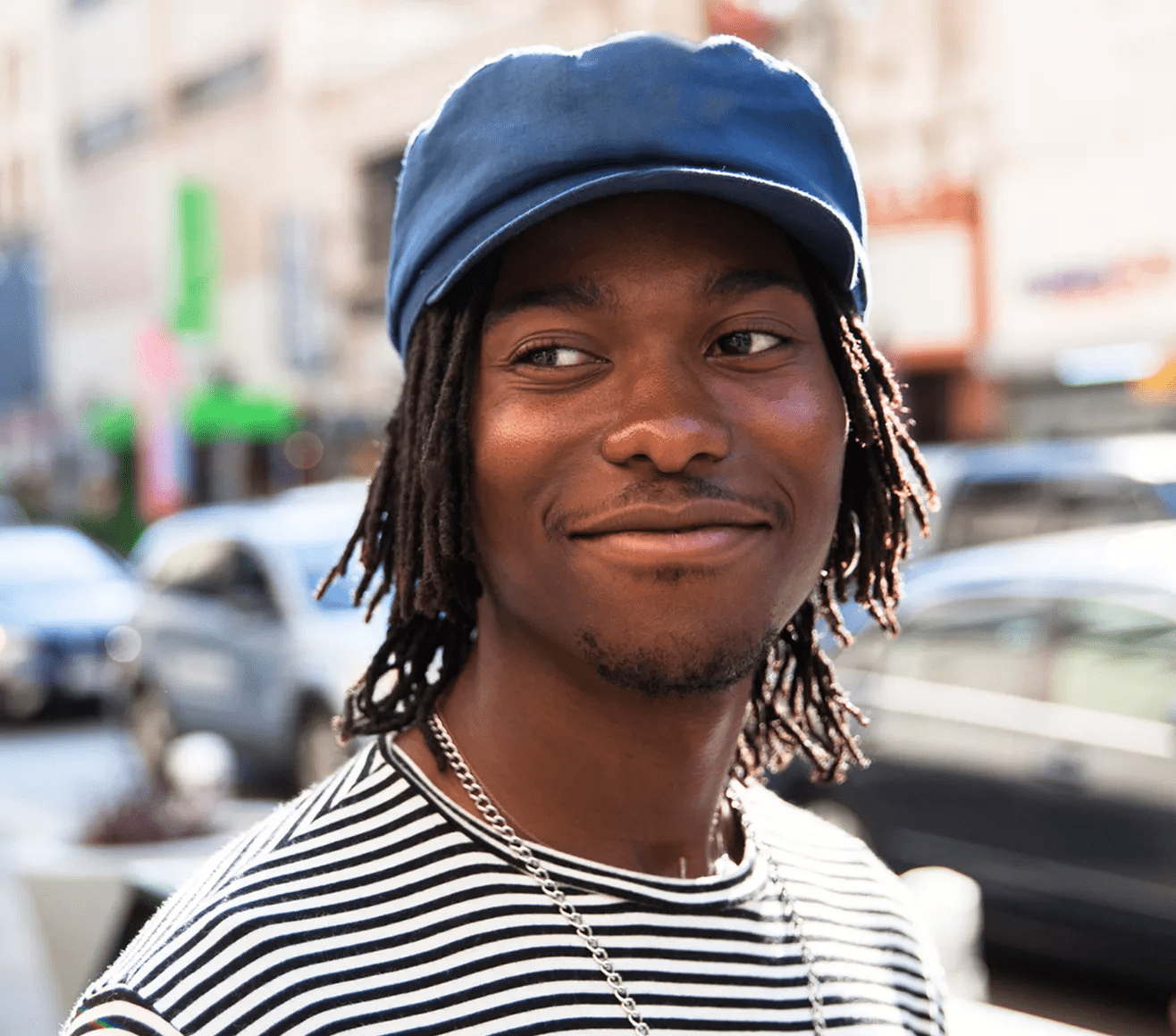 Persona con gorra azul y suéter a rayas