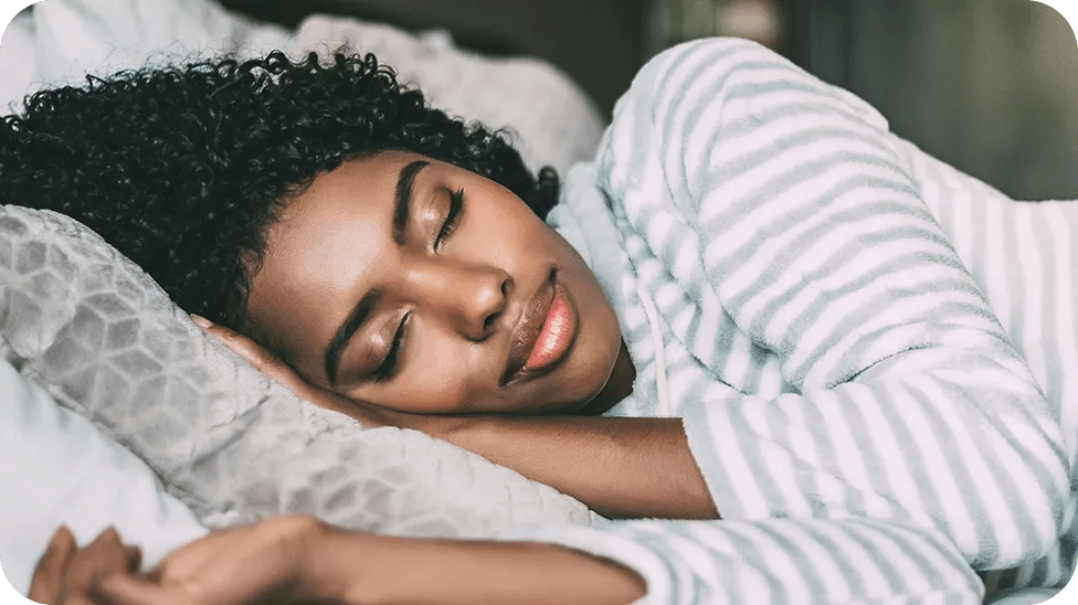 A lady asleep in bed with grey striped shirt