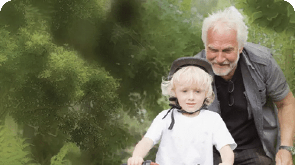 Abuelo enseñando a su nieto a montar en bicicleta