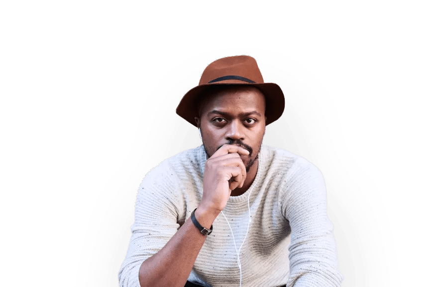 A Black man wearing a brown rimmed hat sits looking at the camera with his right and covering his mouth