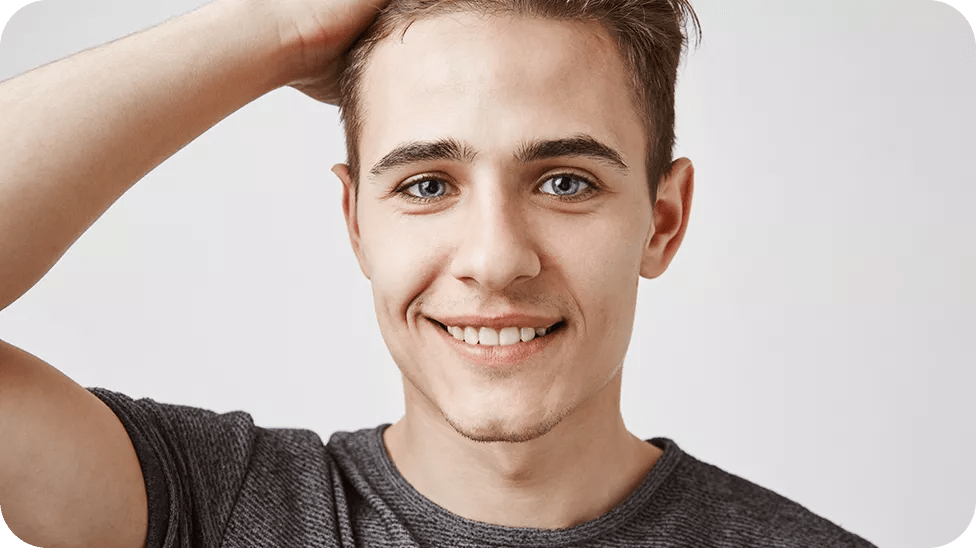 Young man with hand on his head and smiling