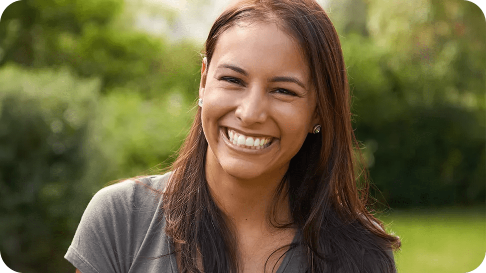 Mulher de cabelos castanhos compridos sorrindo