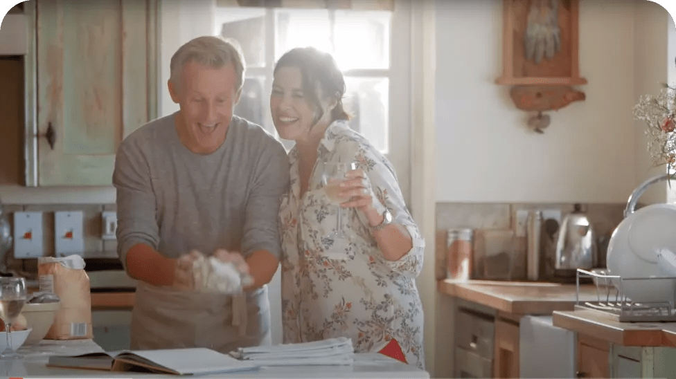 Deux personnes souriantes dans la cuisine.