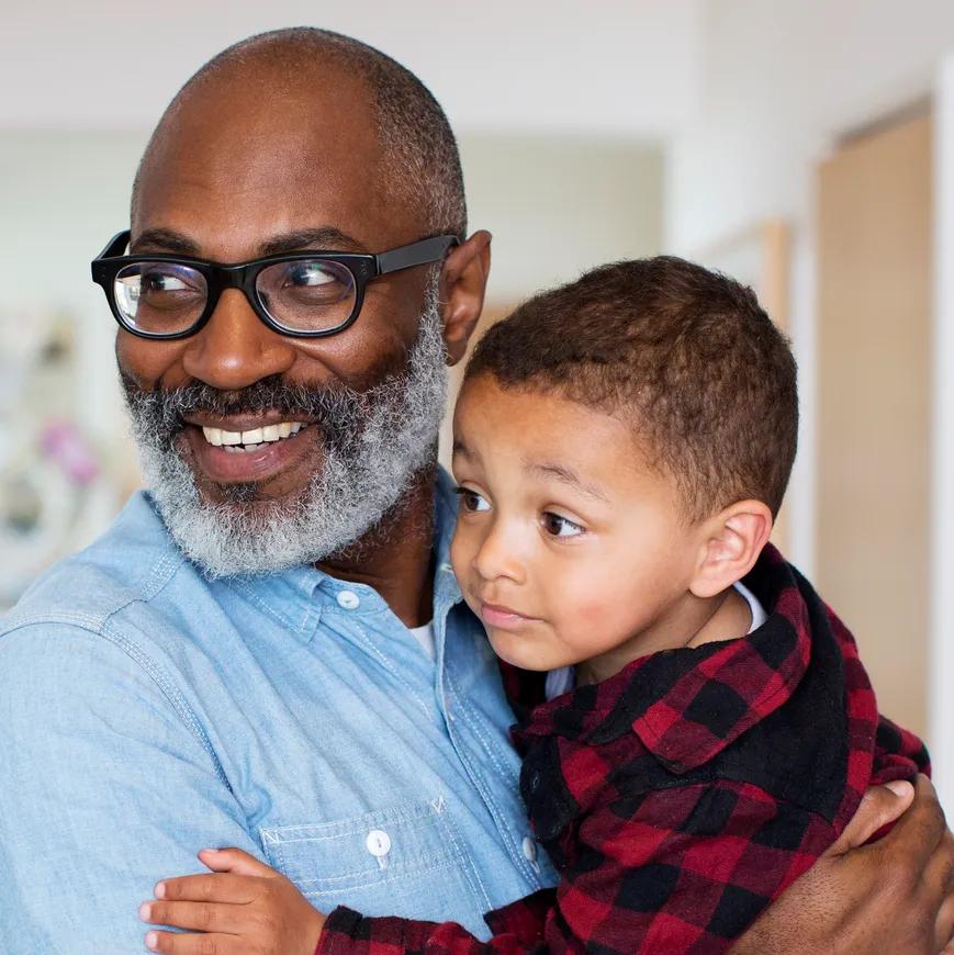 Grand-père souriant et tenant son petit-fils dans ses bras