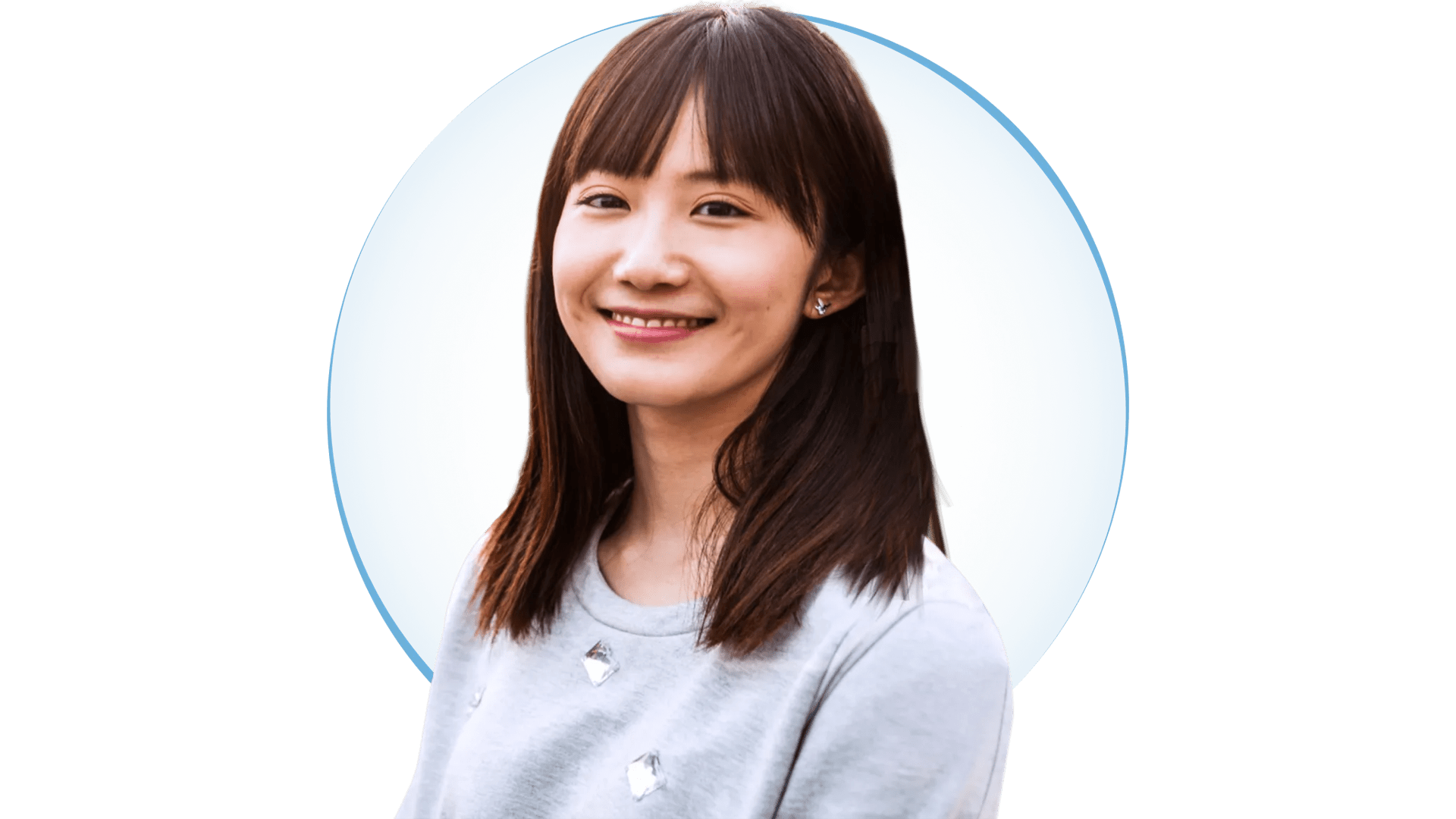 Young Asian woman with shoulder-length hair, and gray blouse. Young Asian woman with shoulder-length hair, and gray blouse smiles while looking at the camera.