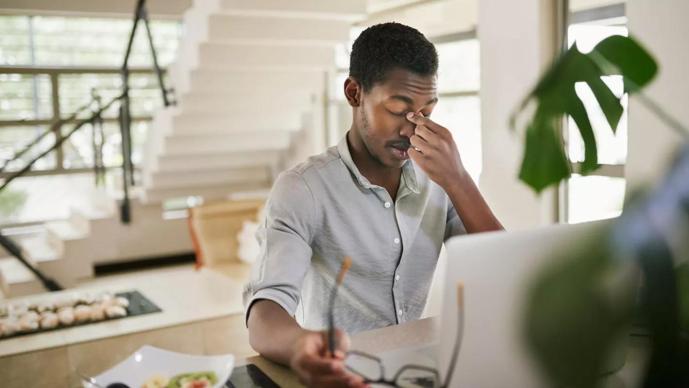 Man taking off glasses looking tired