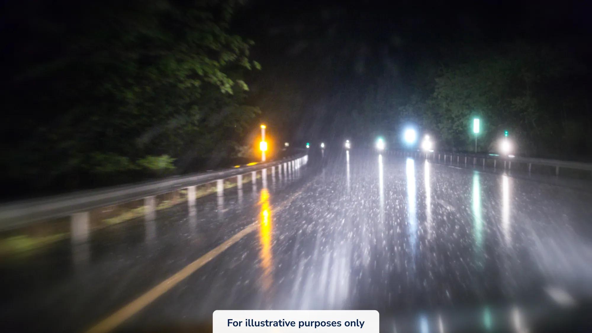 A POV view of driving a car down a dark road while it's raining