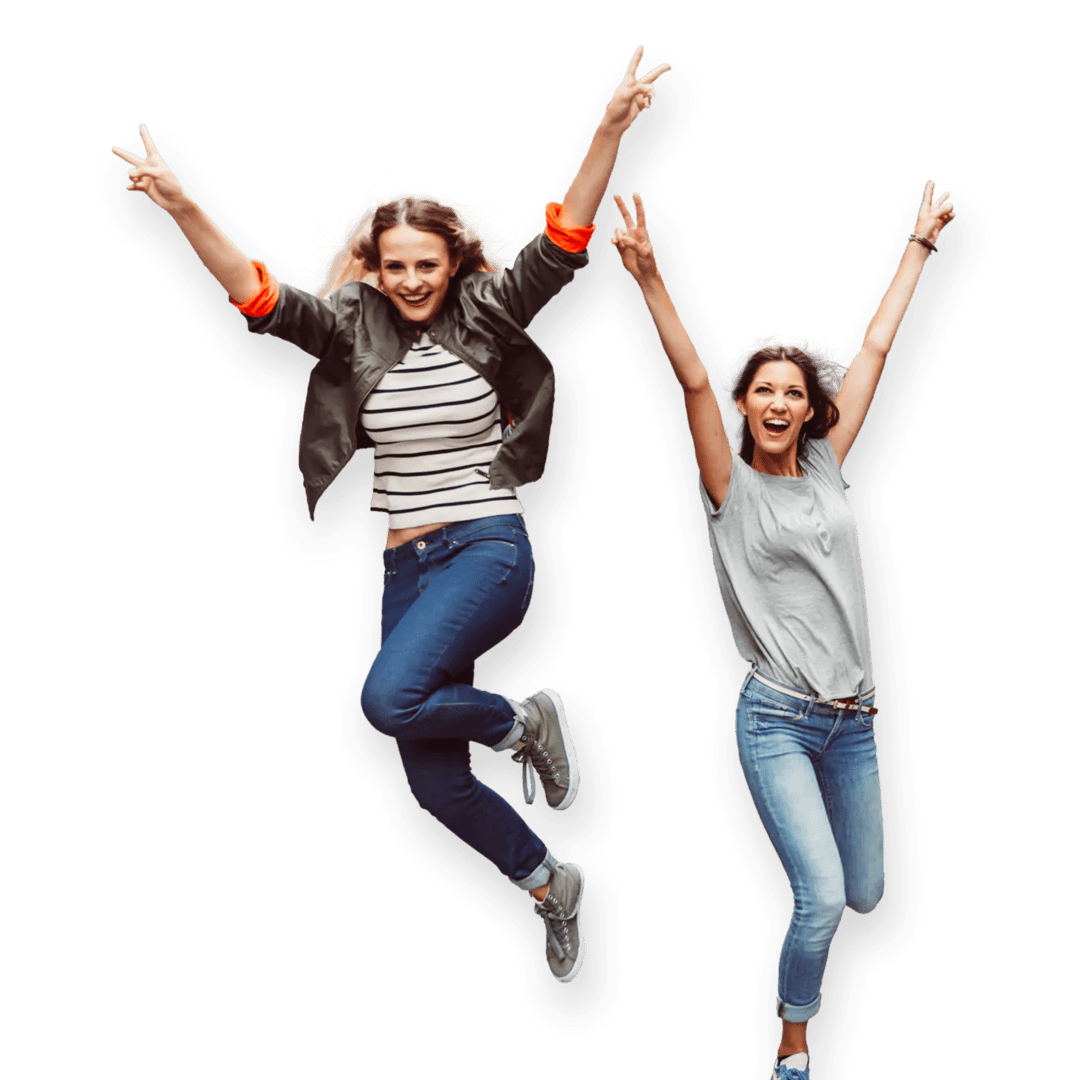 Two happy women in a moment of celebration, jumping with big smiles and arms stretched out