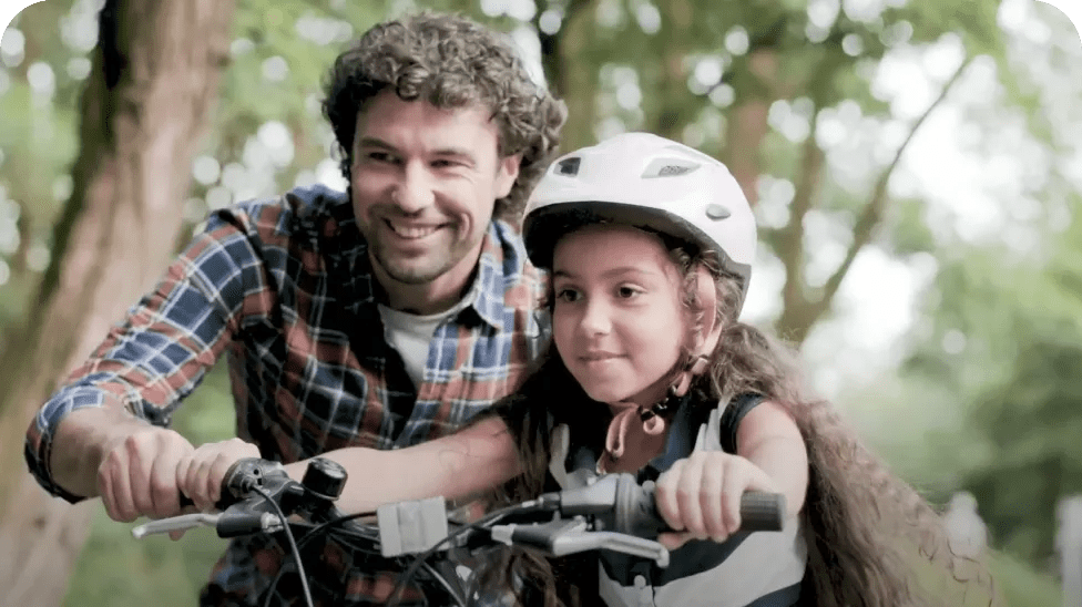 Parent teaching child to ride bike