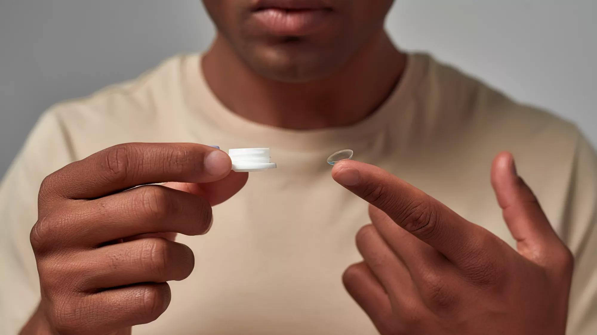 Person holding contact lens on finger