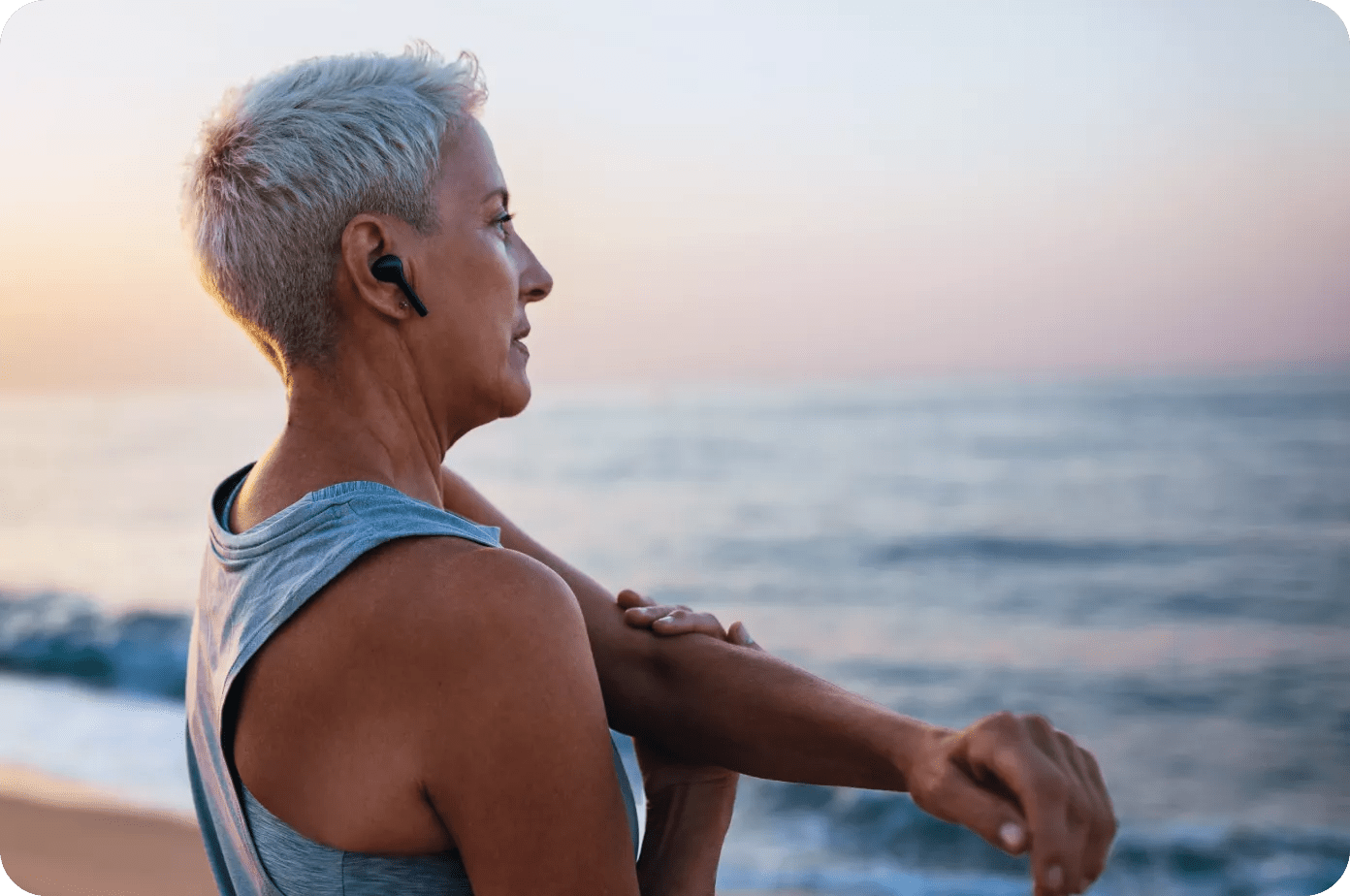 Older woman looking at the sea during sunrise