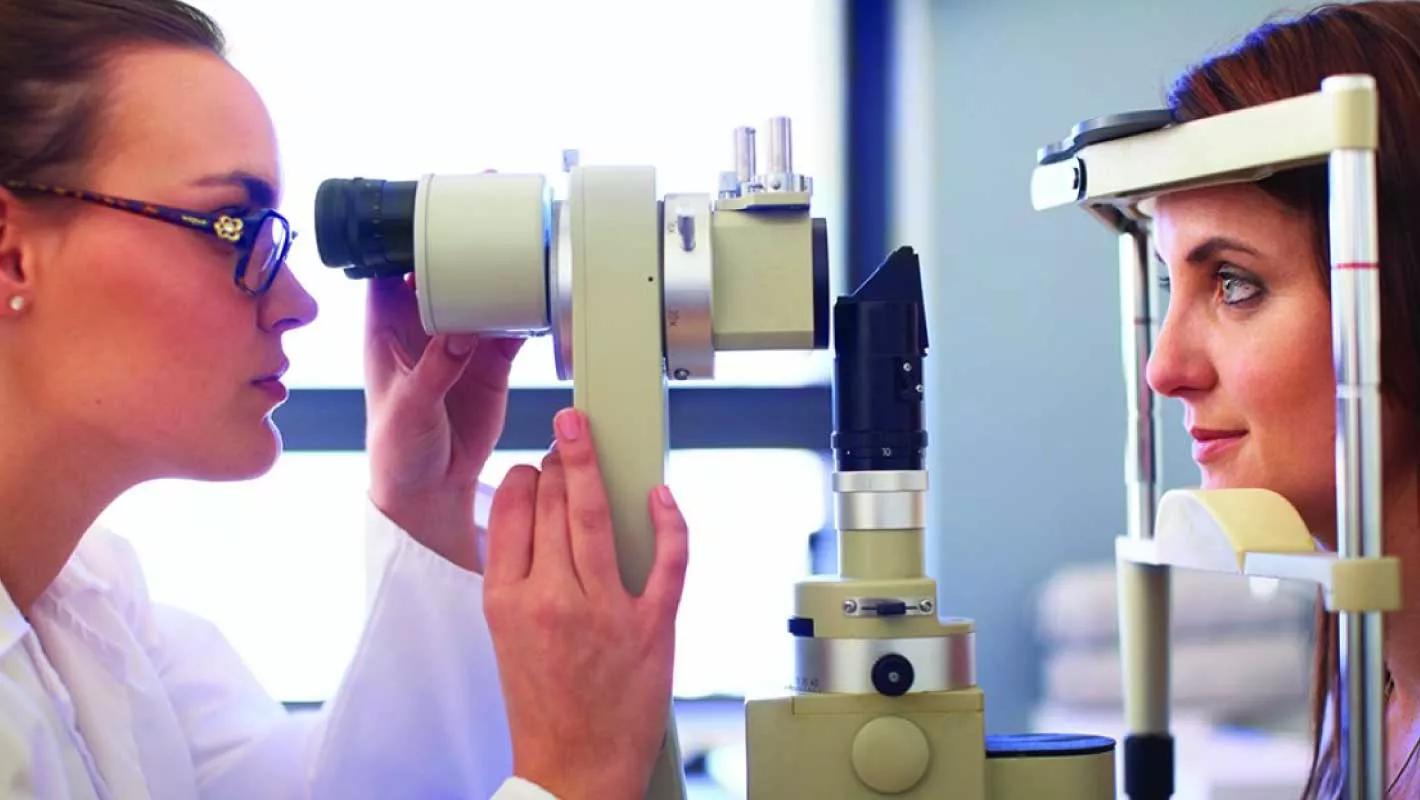 An eye care professional examines a patient's eye.