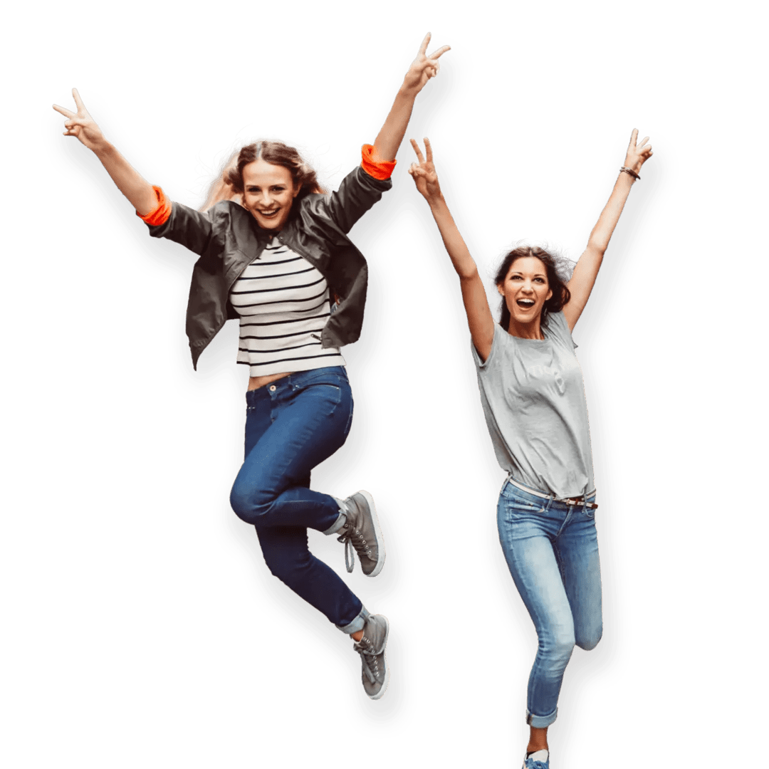 Two happy women in a moment of celebration, jumping with big smiles and arms stretched out