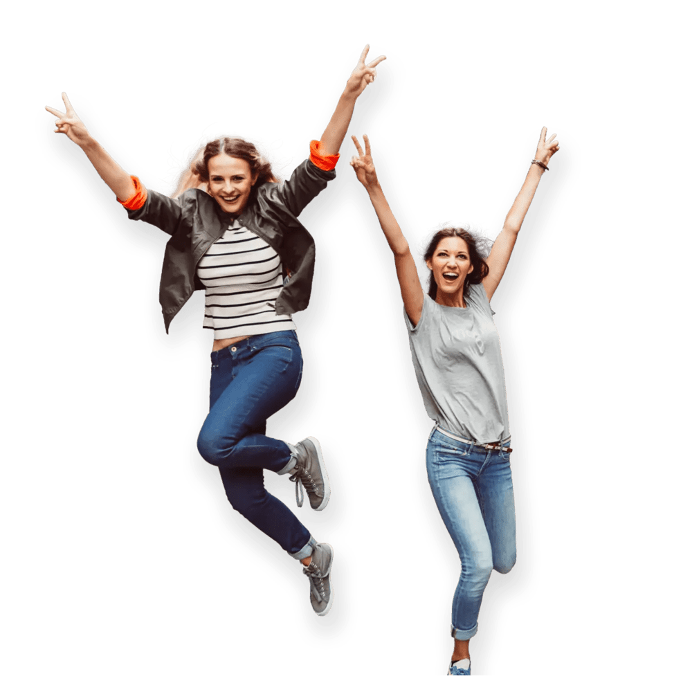 Two happy women in a moment of celebration, jumping with big smiles and arms stretched out